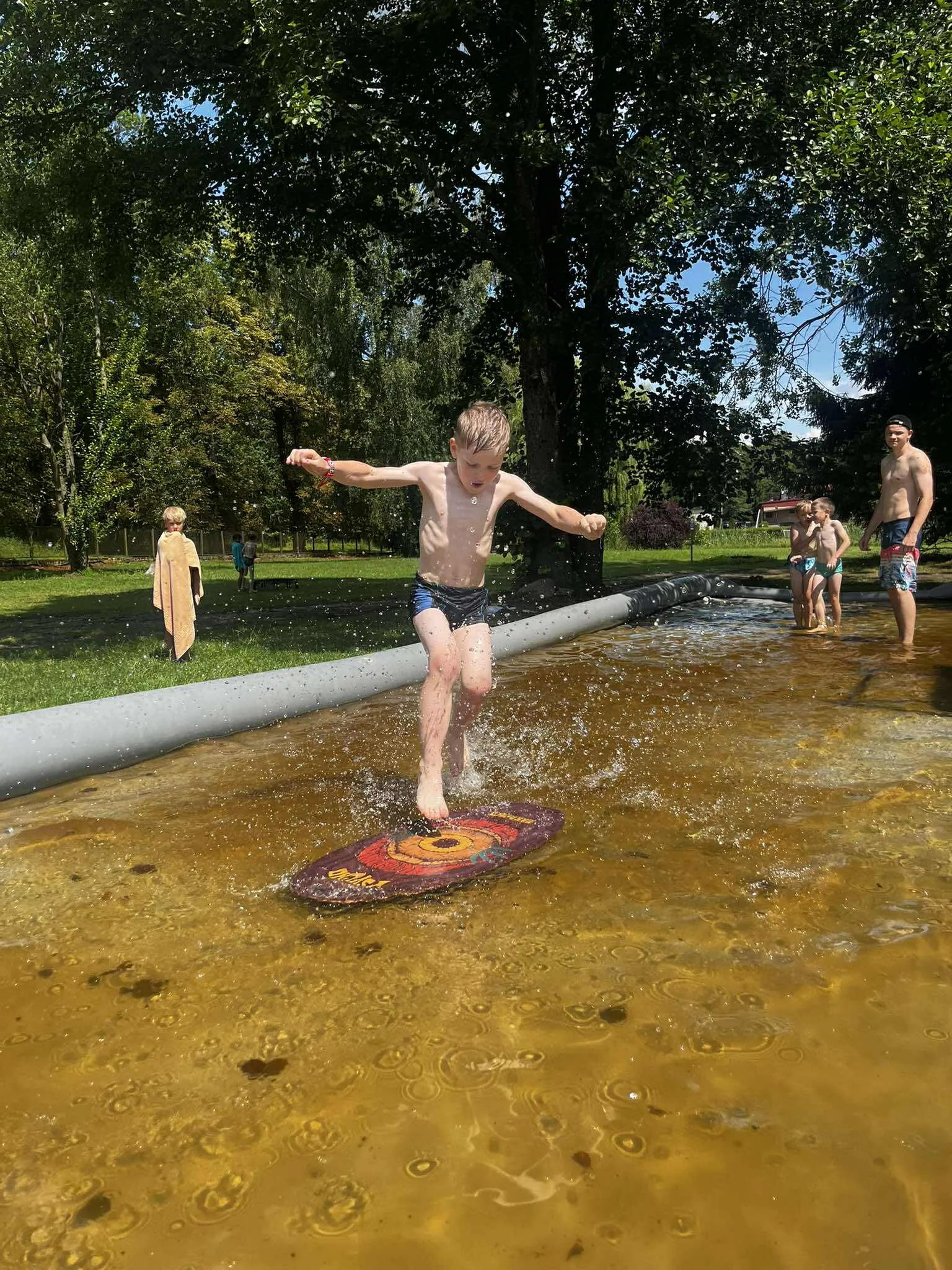 Chłopiec biegnie po wodnym torze — obóz letni Sport21